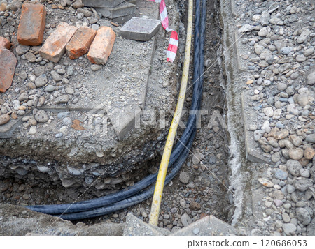 Broken sidewalk. Conducting the cable underground. Cable laying work. Communications in the city. Electrification. 120686053