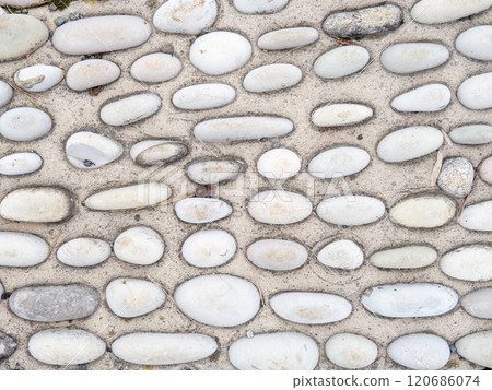 Pattern of sea stones in cement. Ground cover in the park. Background with bumps. Background of beach pebbles and concrete. 120686074