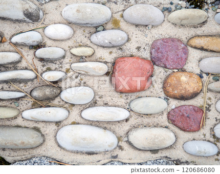 Pattern of sea stones in cement. Ground cover in the park. Background with bumps. Background of beach pebbles and concrete 120686080