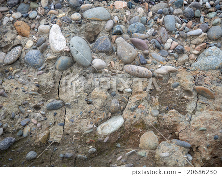Layers of earth on a beach made of pebbles. Soil cut. Cobblestones and earth. After the excavator. Layers of earth on a beach made of pebbles. Soil cut. Cobblestones and earth. After the excavator. 120686230