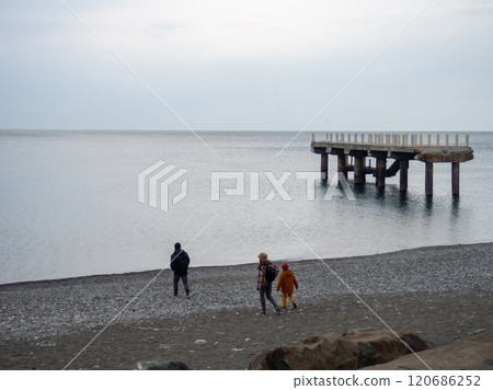People are walking along the pier. Cold season at the resort. Not a season. People are walking along the pier. Cold season at the resort. Not a season. 120686252