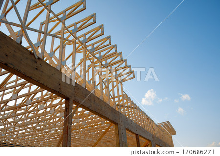 Wooden House Frame Under Construction with Roof Trusses 120686271