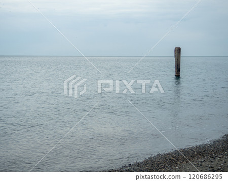 Reinforced concrete pile sticking out of the water. Remains of an old bridge in the sea. Ruined pier. Abandoned. Armature at sea. Destroyed building. Quiet place. Reinforced concrete pile sticking out of the water. Remains of an old bridge in the sea. Ruined pier. Abandoned. Armature at sea. Destroyed building. Quiet place. 120686295