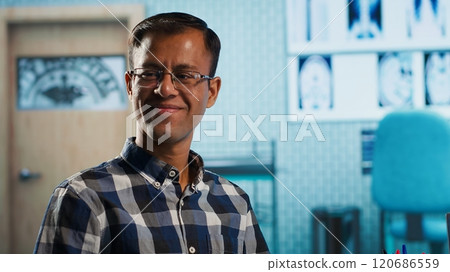 Indian medic explaining diagnostics through test results with her patient at medical office, doing scan interpretation at check up appointment. Healthcare services covered by insurance. Camera A. 120686559