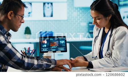 Healthcare professional uses oximeter to measure oxygen levels for patient at check up, diagnostic tools for accurate medical advice. Monitoring pulse and saturation with indicator. Camera A. Healthcare professional uses oximeter to measure oxygen levels for patient at check up, diagnostic tools for accurate medical advice. Monitoring pulse and saturation with indicator. Camera A. 120686602