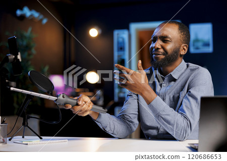 Media star reviewing selfie stick, expressing dissatisfaction with subpar quality of materials used. Content creator shooting video for online channel, displeased with low quality mobile phone holder Media star reviewing selfie stick, expressing dissatisfaction with subpar quality of materials used. Content creator shooting video for online channel, displeased with low quality mobile phone holder 120686653