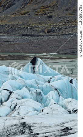 Diamond shaped Vatnajokull glacier forming ice caves in wintry iceland scenery near frozen glacier lagoon. Beautiful massive icebergs and ice chunks create icelandic landscape. 120686788