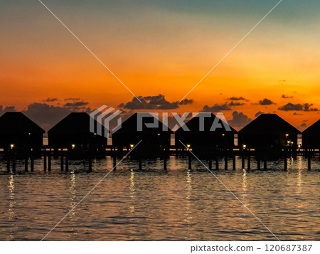 Sunset views from overwater pool villa in Maldives 120687387