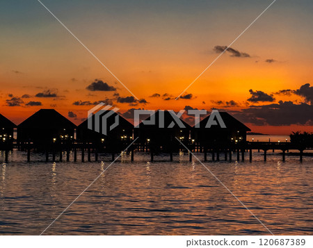Sunset views from overwater pool villa in Maldives 120687389