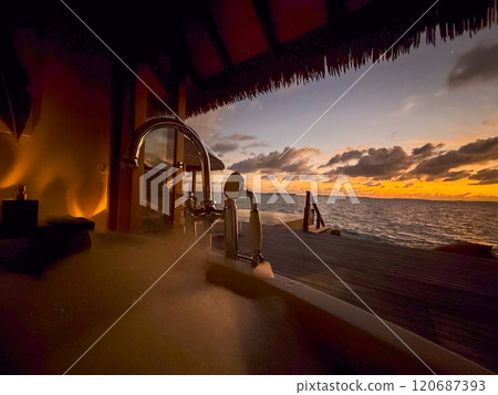 Sunset views from overwater pool villa in Maldives 120687393