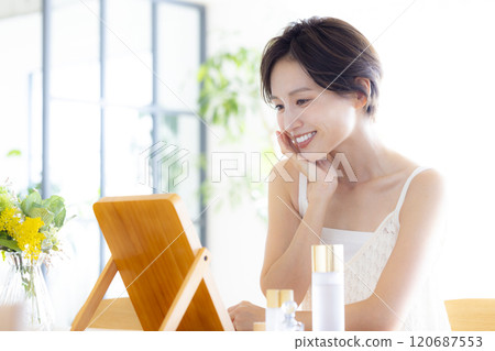 Beauty image: A woman doing skin care while looking in the mirror 120687553
