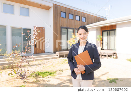 站在房子前面的房地產銷售人員 站在房子前面的房地產銷售人員 120687602
