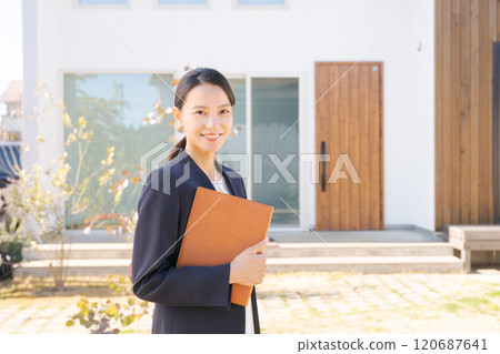 站在房子前面的房地產銷售人員 120687641