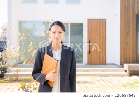 站在房子前面的房地產銷售人員 120687642