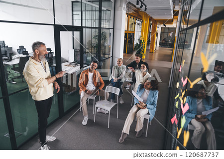 Glad worker making presentation to team in office Glad worker making presentation to team in office 120687737