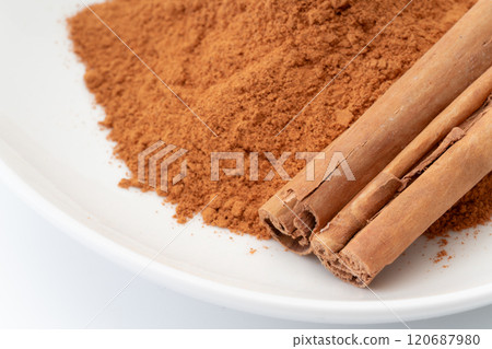 Cinnamon powder and cinnamon sticks close-up 120687980