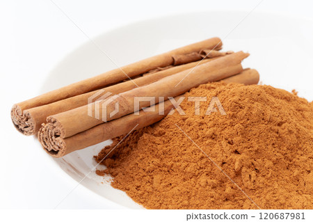 Cinnamon powder and cinnamon sticks close-up 120687981