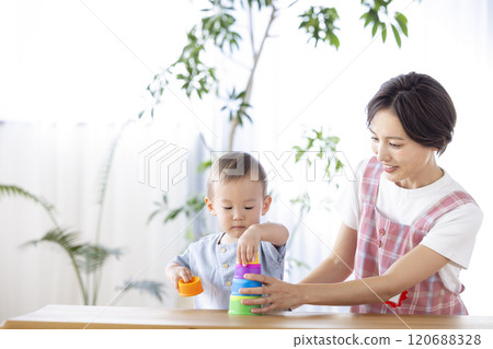 Nursery school children playing with their teachers 120688328