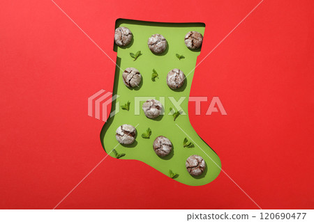 Crinkle cookies, mint leaves and christmas sock on red background, top view Crinkle cookies, mint leaves and christmas sock on red background, top view 120690477