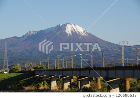 A JR Sanin Main Line bridge crossing the Hino River towards the foot of Mt. Daisen, covered with its first snow. 120690632