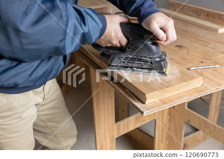 Sanding the surface of cedar boards 120690773