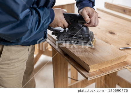 Sanding the surface of cedar boards 120690776