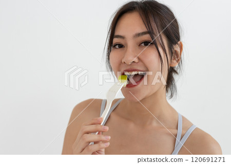 Asian attractive lady sportswear healthy eating salad vegetables over white background. Female eat fruit healthy food for weight loss and exercise. 120691271