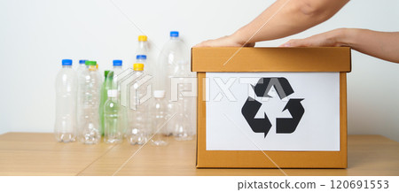Volunteer keep plastic bottle into paper box at home or office. Hand Sorting Recycle garbage. Ecology, Environmental, pollution, Dispose recycling, waste management and trash Separation concept 120691553
