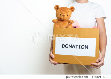 Kid Donation, Charity, Volunteer, Giving and Delivery Concept. Hand holding Bear doll and Clothes into Donation box at home for support and help poor, refugee and homeless people. Copy space for text Kid Donation, Charity, Volunteer, Giving and Delivery Concept. Hand holding Bear doll and Clothes into Donation box at home for support and help poor, refugee and homeless people. Copy space for text 120691699