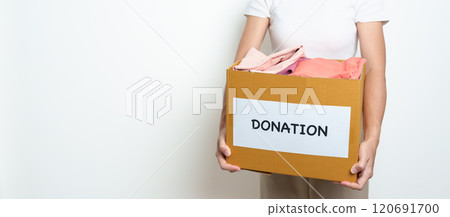 Donation, Charity, Volunteer, Giving and Delivery Concept. People donate Clothes into Donation box at home or office for support and help poor, refugee and homeless people. Copy space for text Donation, Charity, Volunteer, Giving and Delivery Concept. People donate Clothes into Donation box at home or office for support and help poor, refugee and homeless people. Copy space for text 120691700