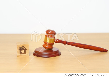 Family Law, Real Estate, Home, property Tax, Auction and Bidding concepts. small toy house model with gavel justice hammer on desk in courthouse. 120691720
