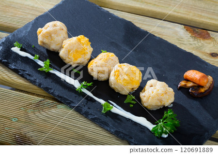 Dish of dumplings with tasty white fish served with greens at plate 120691889