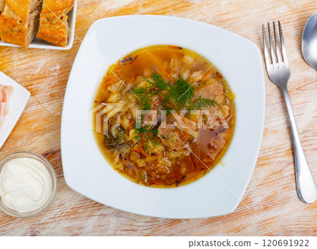 Soup of cabbage Shchi with pork and vegetables, served in plate 120691922