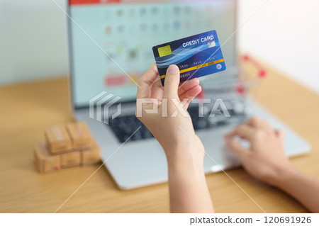 woman hand holding credit card and using laptop with mobile phone for online shopping while making order. Marketplace platform website, technology, ecommerce, shipping delivery and online payment 120691926