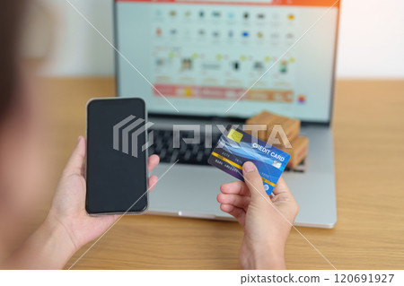 woman hand holding credit card and using laptop with mobile phone for online shopping while making order. Marketplace platform website, technology, ecommerce, shipping delivery and online payment 120691927