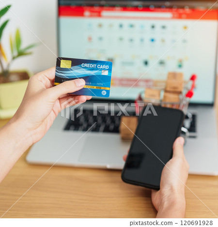 woman hand holding credit card and using laptop with mobile phone for online shopping while making order. Marketplace platform website, technology, ecommerce, shipping delivery and online payment 120691928