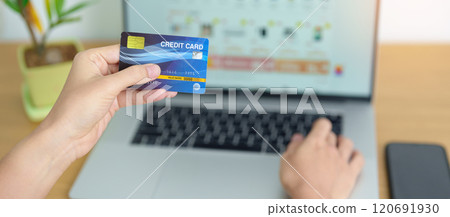 woman hand holding credit card and using laptop with mobile phone for online shopping while making order. Marketplace platform website, technology, ecommerce, digital banking and online payment 120691930