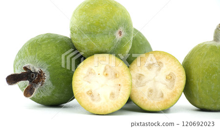 Close-up of fresh, green feijoa fruits, including both whole and sliced, showcasing their texture Close-up of fresh, green feijoa fruits, including both whole and sliced, showcasing their texture 120692023