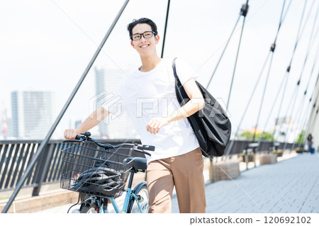 Young man commuting by bicycle Young man commuting by bicycle 120692102