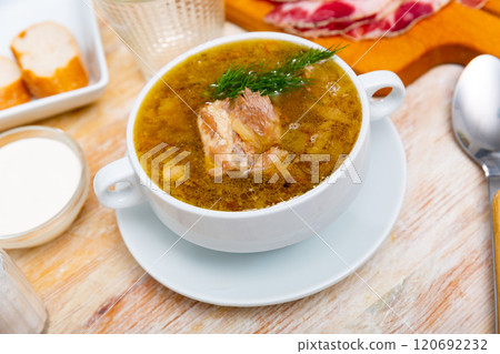 Soup of cabbage with boiled vegetables and pork broth, served in plate 120692232