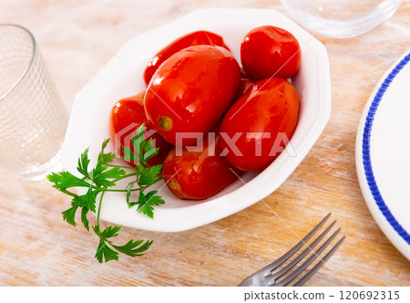 Marinated tomatoes served on white plate decorated with parsle Marinated tomatoes served on white plate decorated with parsle 120692315