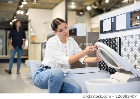 Woman choosing bathroom toilet bowl and utensils for his home 120692407