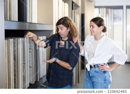 in construction department, male builder with wife choose facing plates for apartment repairs 120692465