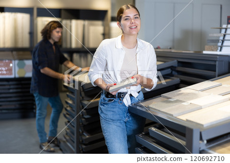 female buyer inspects small decorative tiles for redecorate apartment of new flat. Interior decor 120692710