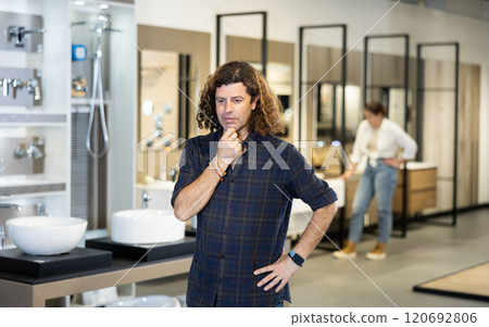 Confident male customer looking around in bathroom section of hardware store 120692806