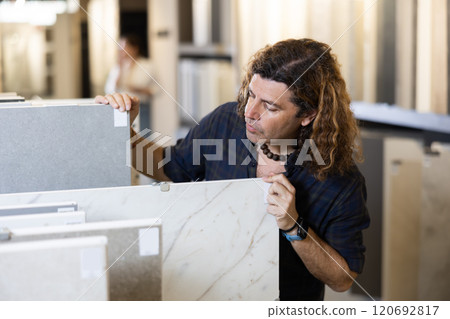 In construction mall,man checks drawing of decorative slabs for suspended ceiling In construction mall,man checks drawing of decorative slabs for suspended ceiling 120692817