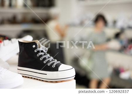 Sneakers displayed on shelf in shoe store 120692837