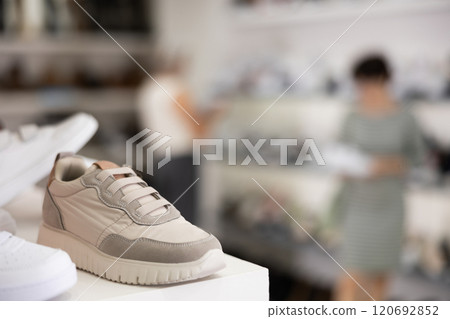 There are sneakers and sports shoes on shelf in store 120692852
