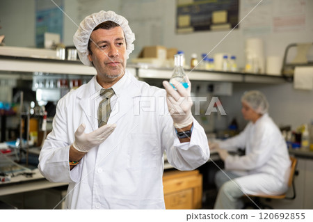 Portrait of an adult male using equipment to work in a laboratory 120692855