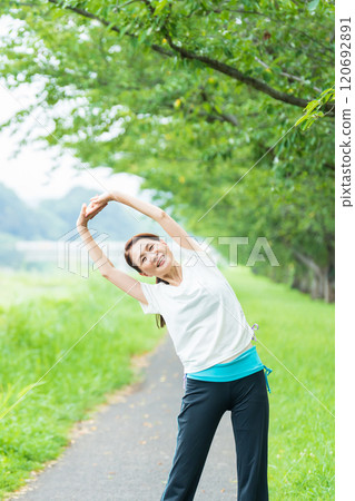 Middle-aged woman stretching in the park 120692891